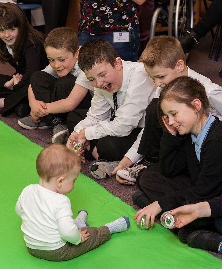 Children engaging with the baby in a Roots Of Empathy session