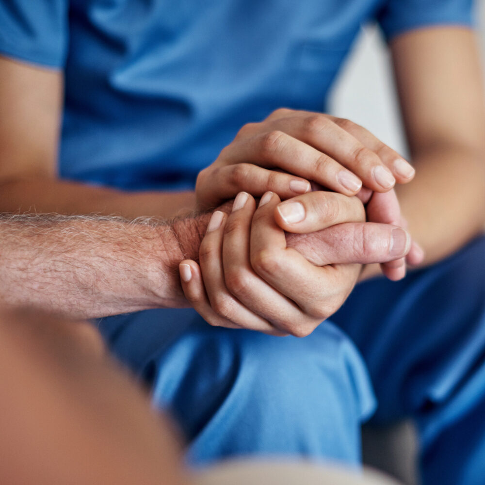 Nurse holding patients hand